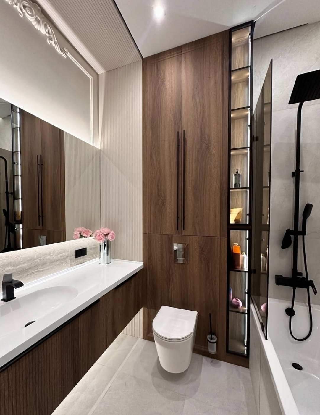 თანამედროვე აბაზანის ინტერიერი მაღალი ხარისხის სანტექნიკით, ფლაგმენტური დიზაინით და ფუნქციური განლაგებით.