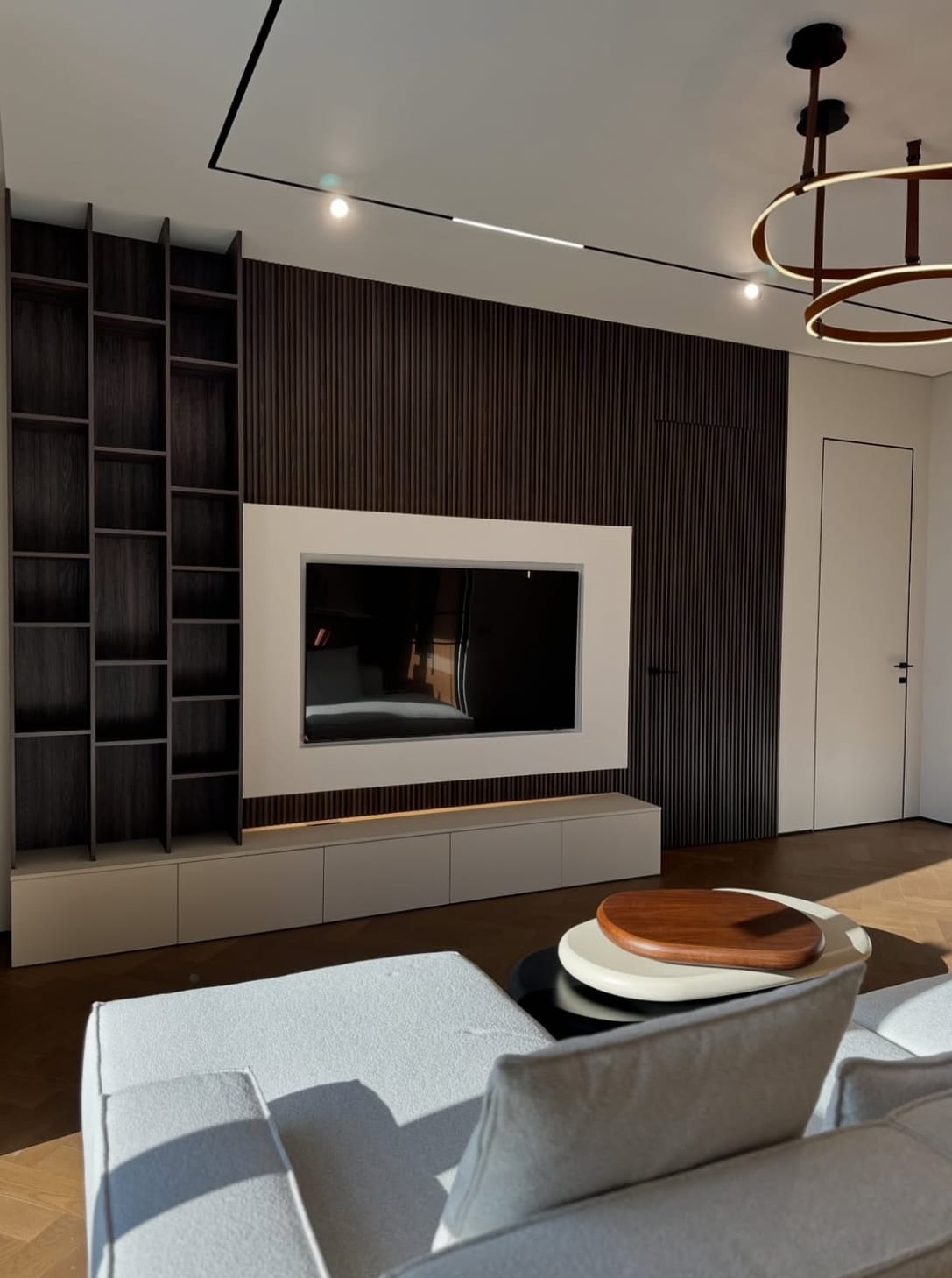 თანამედროვე TV კედელის ინტერიერი მაღალი ხარისხის მასალებით, ფუნქციური სივრცით და სტილური დიზაინით.